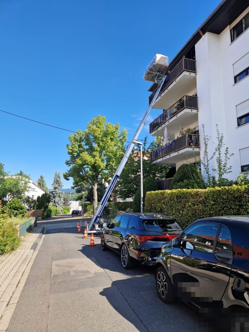 Furniture lift raising a sofa over a balcony to an upper floor in Wiesbaden